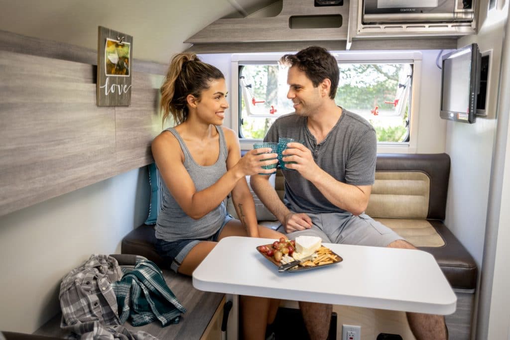 couple dining inside their teardrop camper